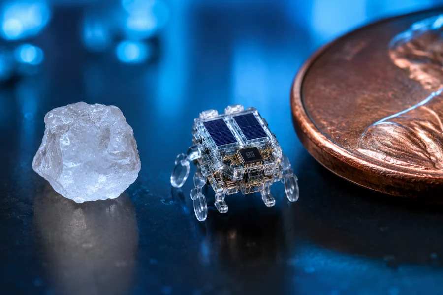 Sub-millimeter microrobot beside a salt grain and copper penny for scale